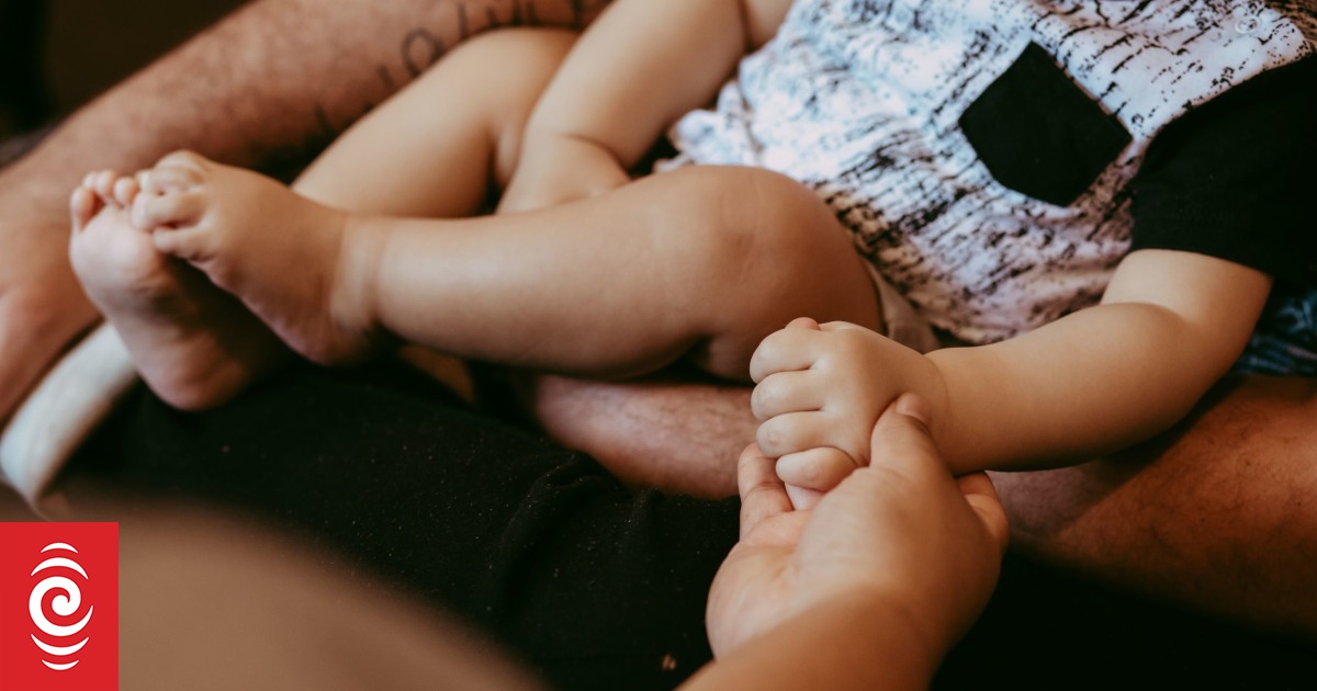 4LEJ1KK Mother holding hands of baby in transitional housing jpg