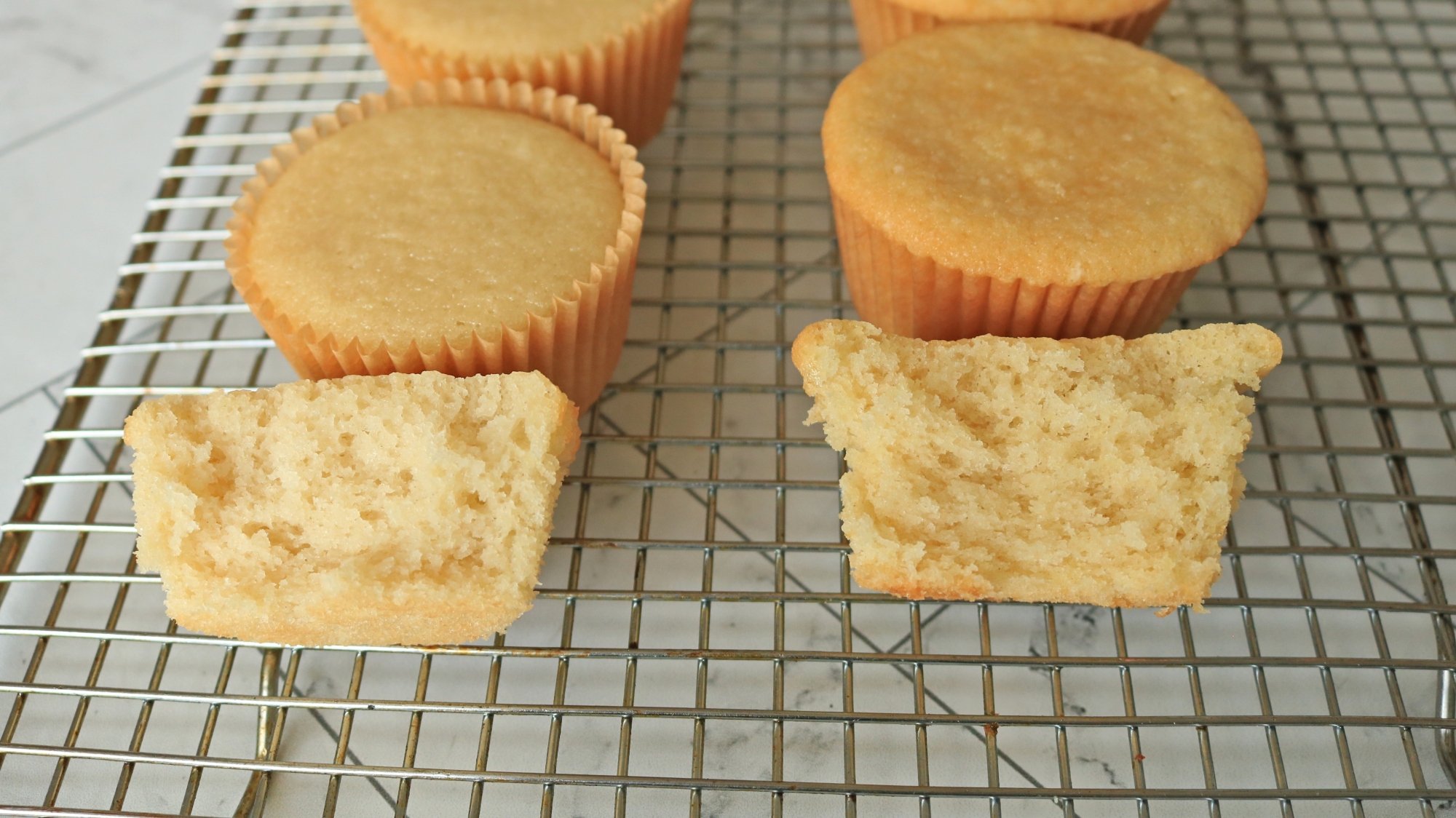 Two types of cupcakes on a wire rack.