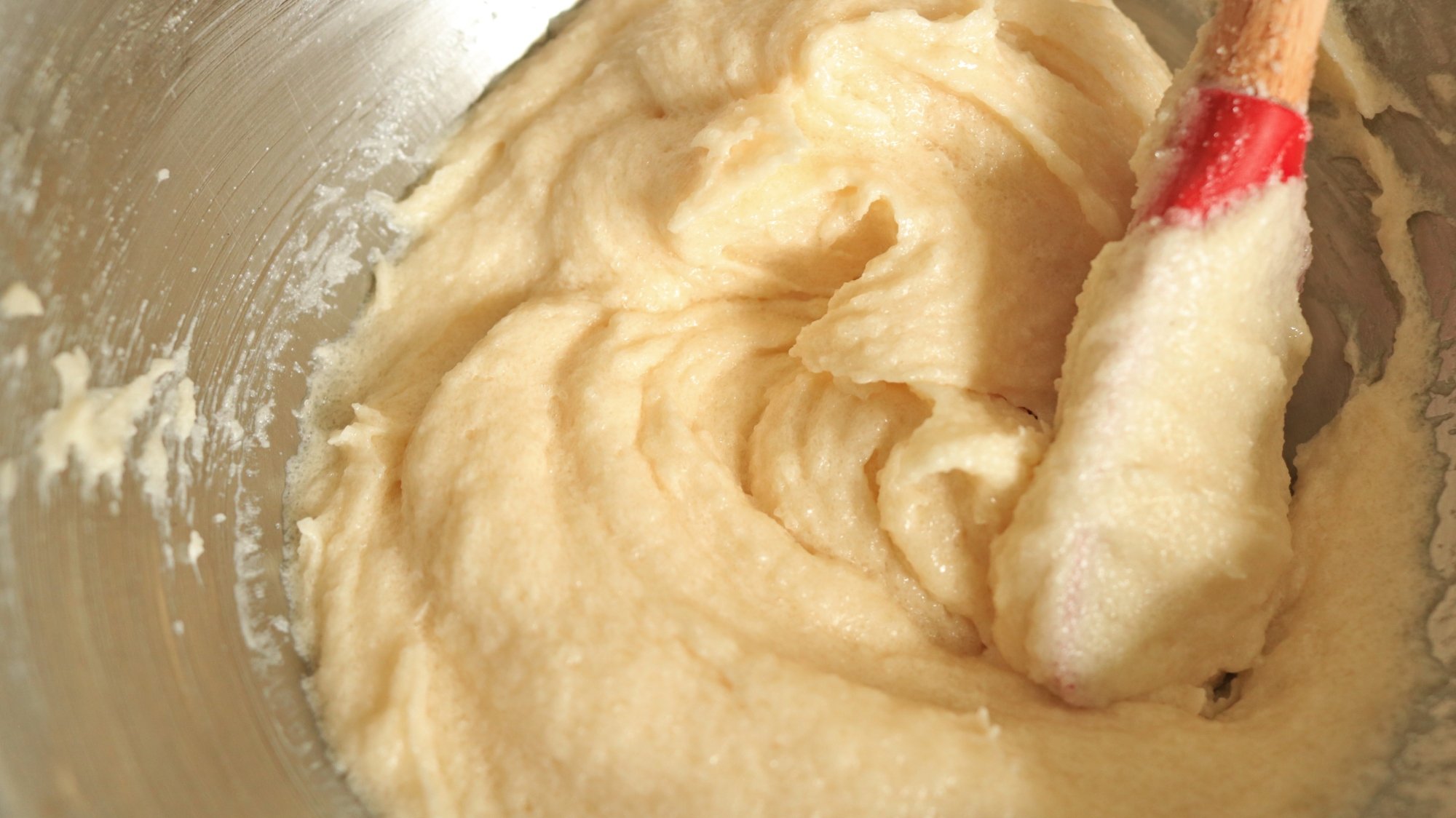 A creamy mixture of butter, sugar, and aquafaba mixed together in a bowl.
