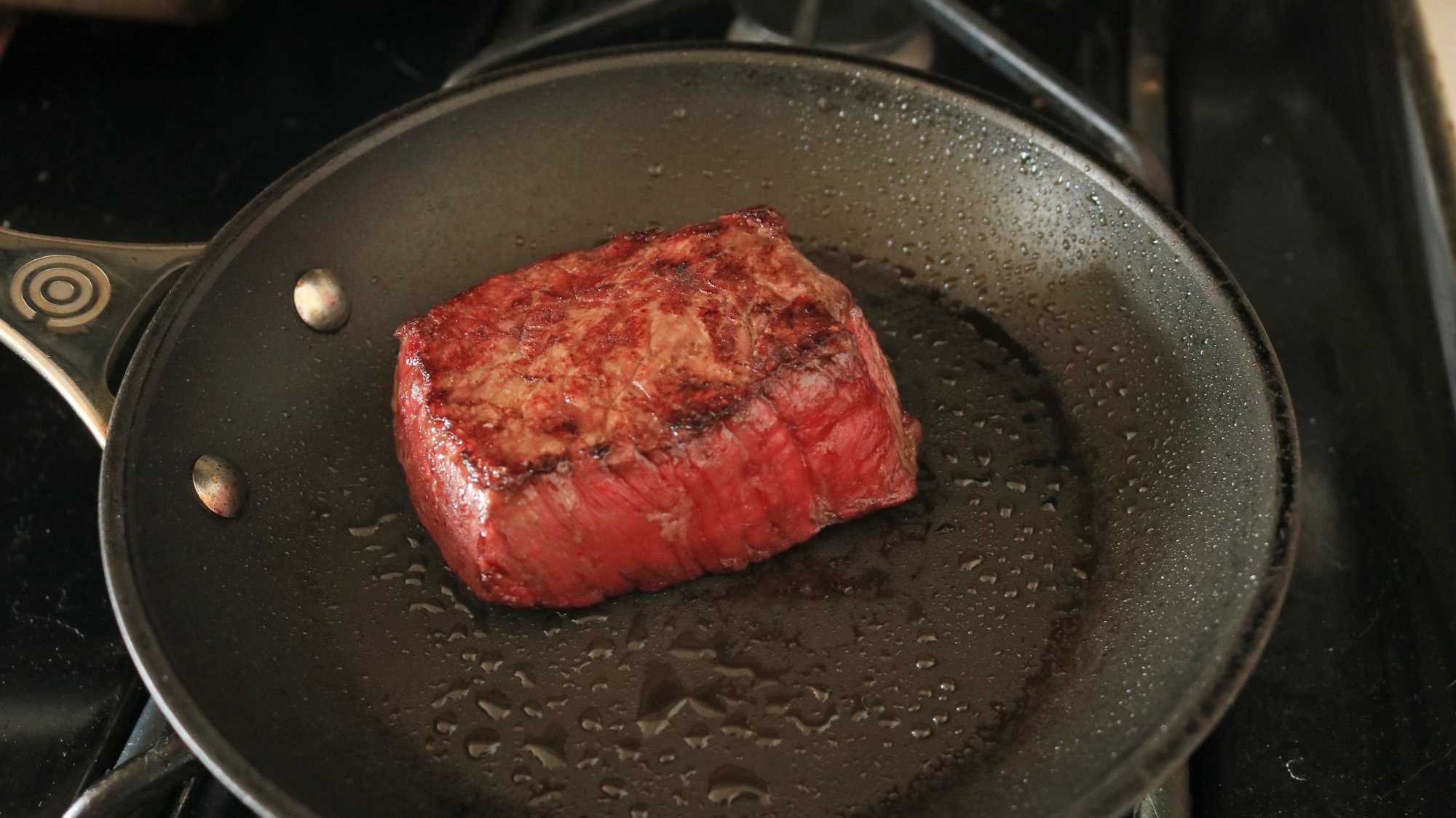 Reverse Searing a Steak Is Faster in the Air Fryer 2 A steak searing in a frying pan.