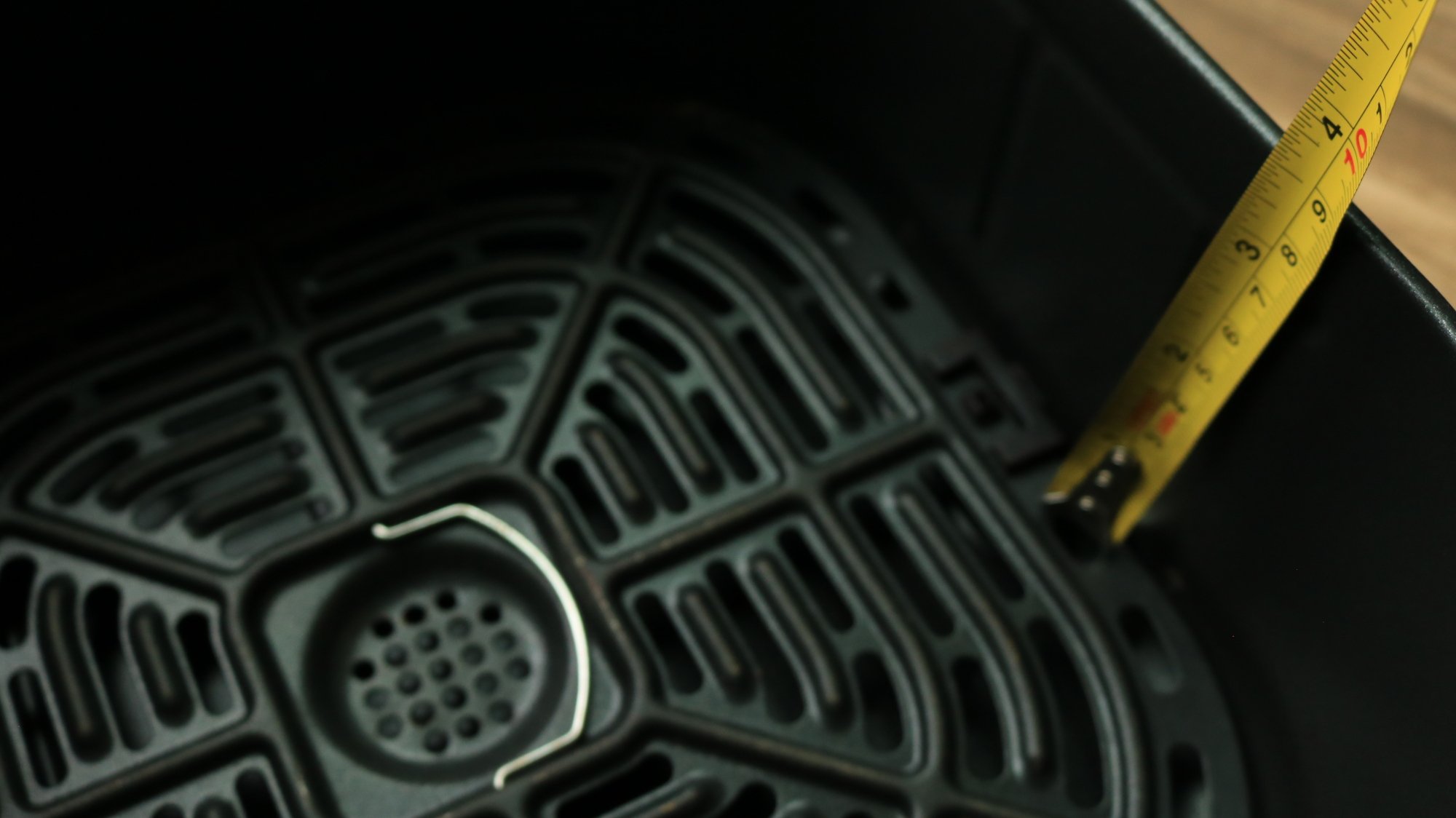 A measuring tape inside of an air fryer basket